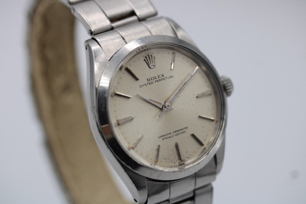 A stainless steel Rolex Oyster Perpetual wrist watch featuring a silver dial with baton indices and an integrated steel bracelet. View III