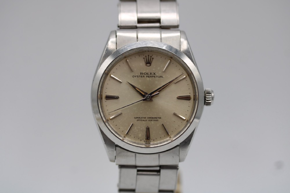 A stainless steel Rolex Oyster Perpetual wrist watch featuring a silver dial with baton indices and an integrated steel bracelet. View VI