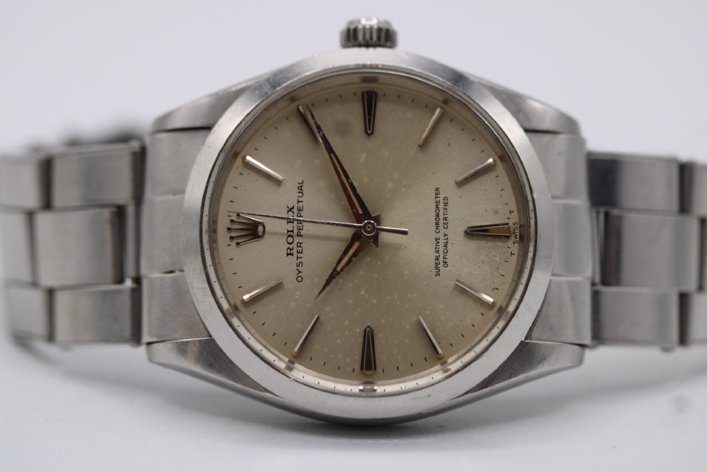 A stainless steel Rolex Oyster Perpetual wrist watch featuring a silver dial with baton indices and an integrated steel bracelet. View VIII