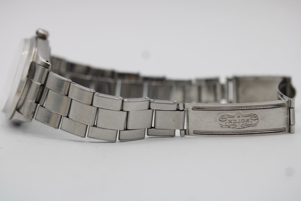 A stainless steel Rolex Oyster Perpetual wrist watch featuring a silver dial with baton indices and an integrated steel bracelet. View IX