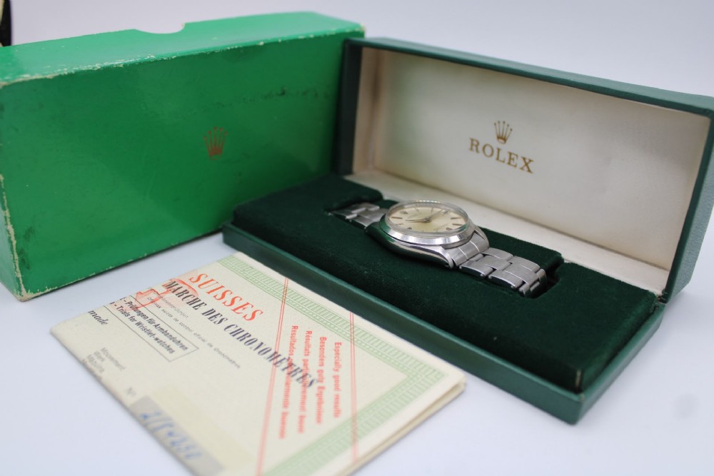 A stainless steel Rolex Oyster Perpetual wrist watch featuring a silver dial with baton indices and an integrated steel bracelet. View XI