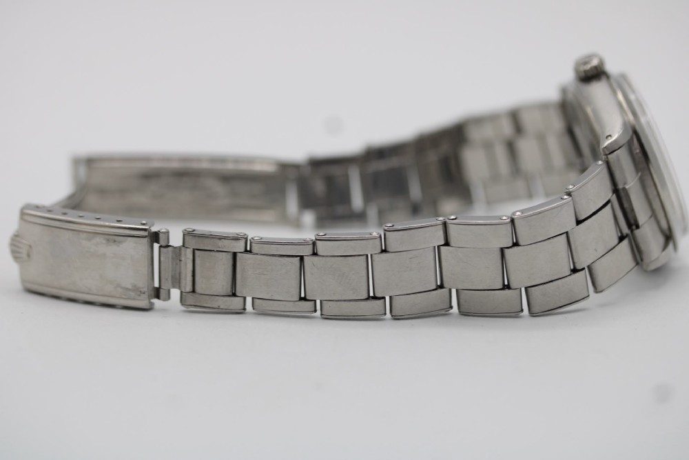 A stainless steel Rolex Oyster Perpetual wrist watch featuring a silver dial with baton indices and an integrated steel bracelet. View XII