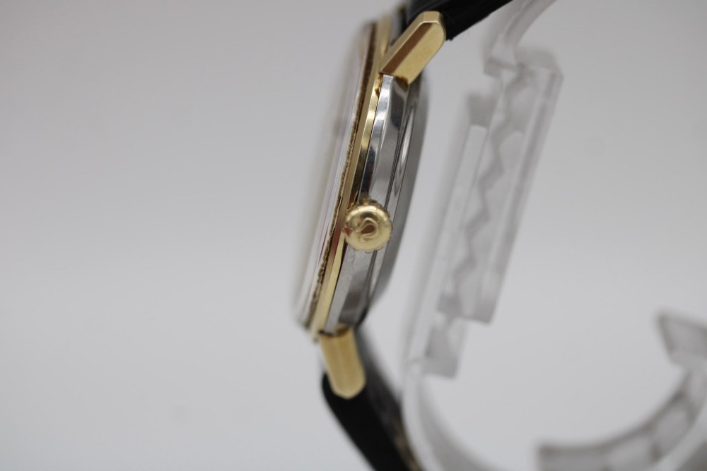 A vintage gold-plated Omega Seamaster DeVille automatic wristwatch with a white textured dial, gold baton indices, date window, and black leather strap. View IX