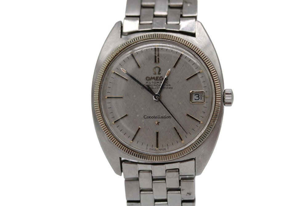 A 1969 vintage Omega Constellation wristwatch featuring a stainless steel case, fluted bezel, silver linen dial, date window, and steel link bracelet. View II