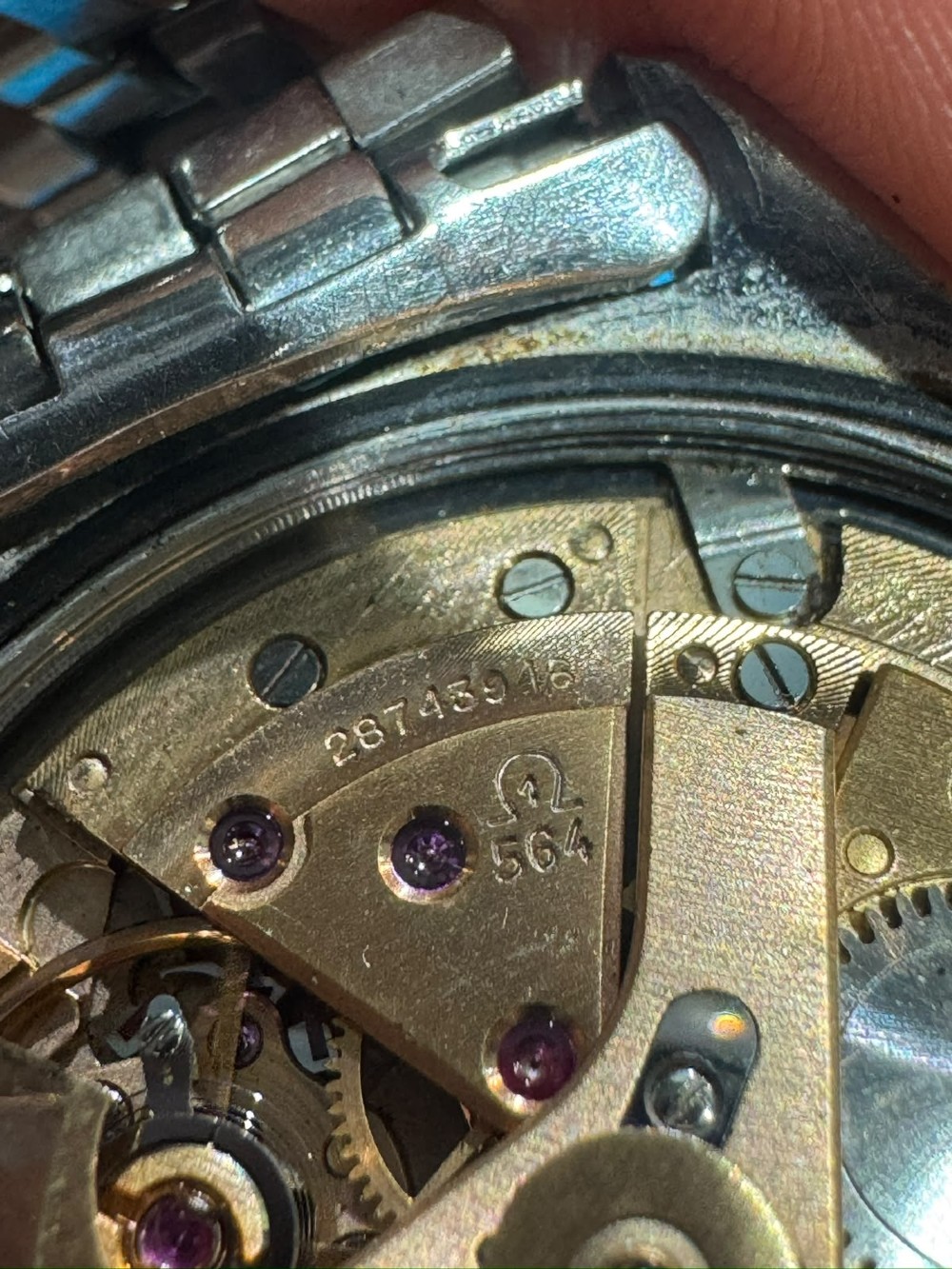 A 1969 vintage Omega Constellation wristwatch featuring a stainless steel case, fluted bezel, silver linen dial, date window, and steel link bracelet. View XII