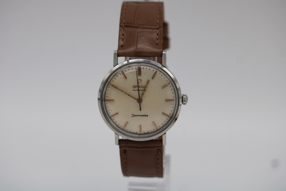 A vintage 1961 Omega Seamaster wristwatch with a stainless steel case, silver dial, applied baton hour markers, and a tan leather strap. View II