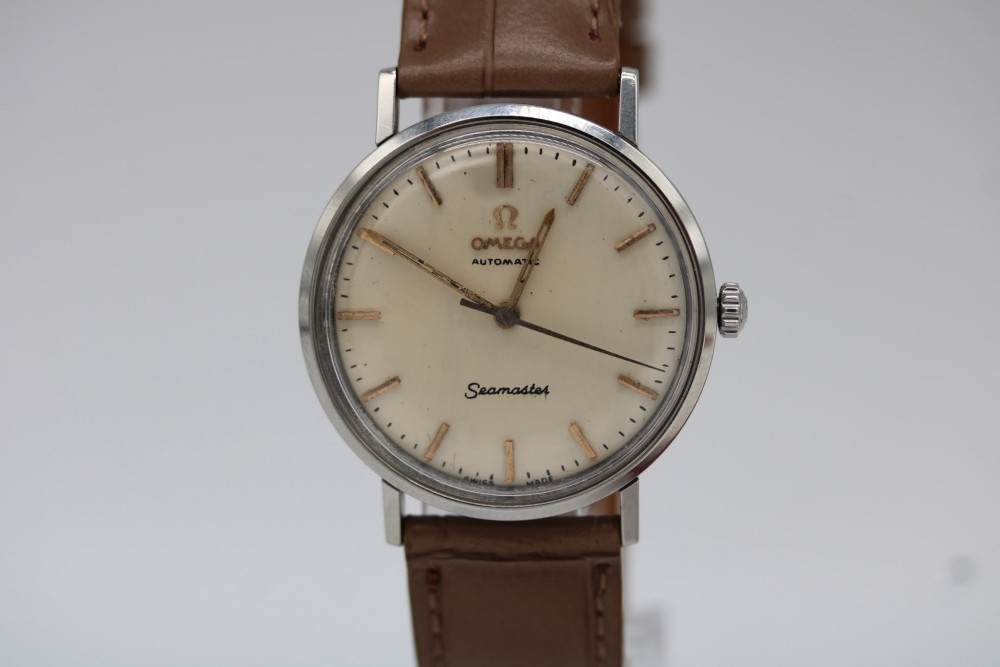A vintage 1961 Omega Seamaster wristwatch with a stainless steel case, silver dial, applied baton hour markers, and a tan leather strap. View III