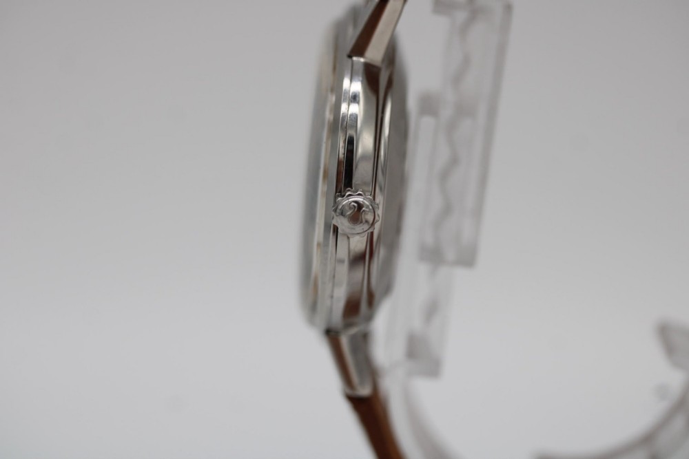 A vintage 1961 Omega Seamaster wristwatch with a stainless steel case, silver dial, applied baton hour markers, and a tan leather strap. View IX