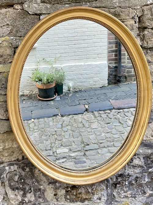 A MID VICTORIAN OVAL GILTWOOD MIRROR - ADDITIONAL PHOTO 1