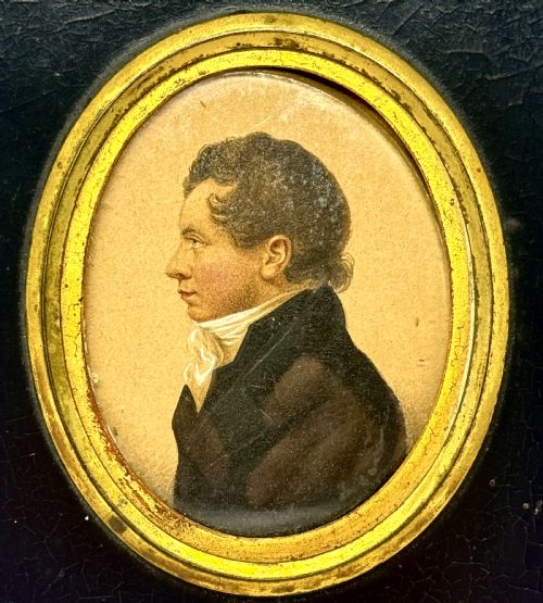 fig 1. A Regency profile portrait miniature of a gentleman in a white cravat, set within an oval gilt bezel and rectangular black ebonised frame.