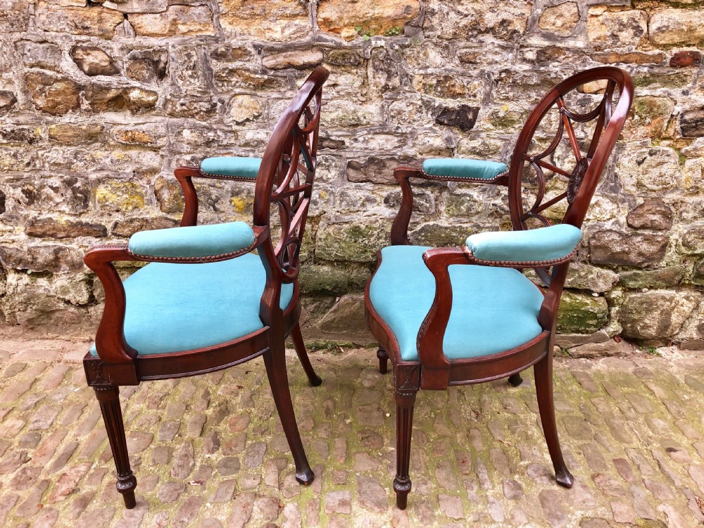 Pair of Sheraton Revival mahogany elbow chairs with oval wheel-back splats, carved rosettes, turquoise velvet seats, and turned reeded front legs. View VI