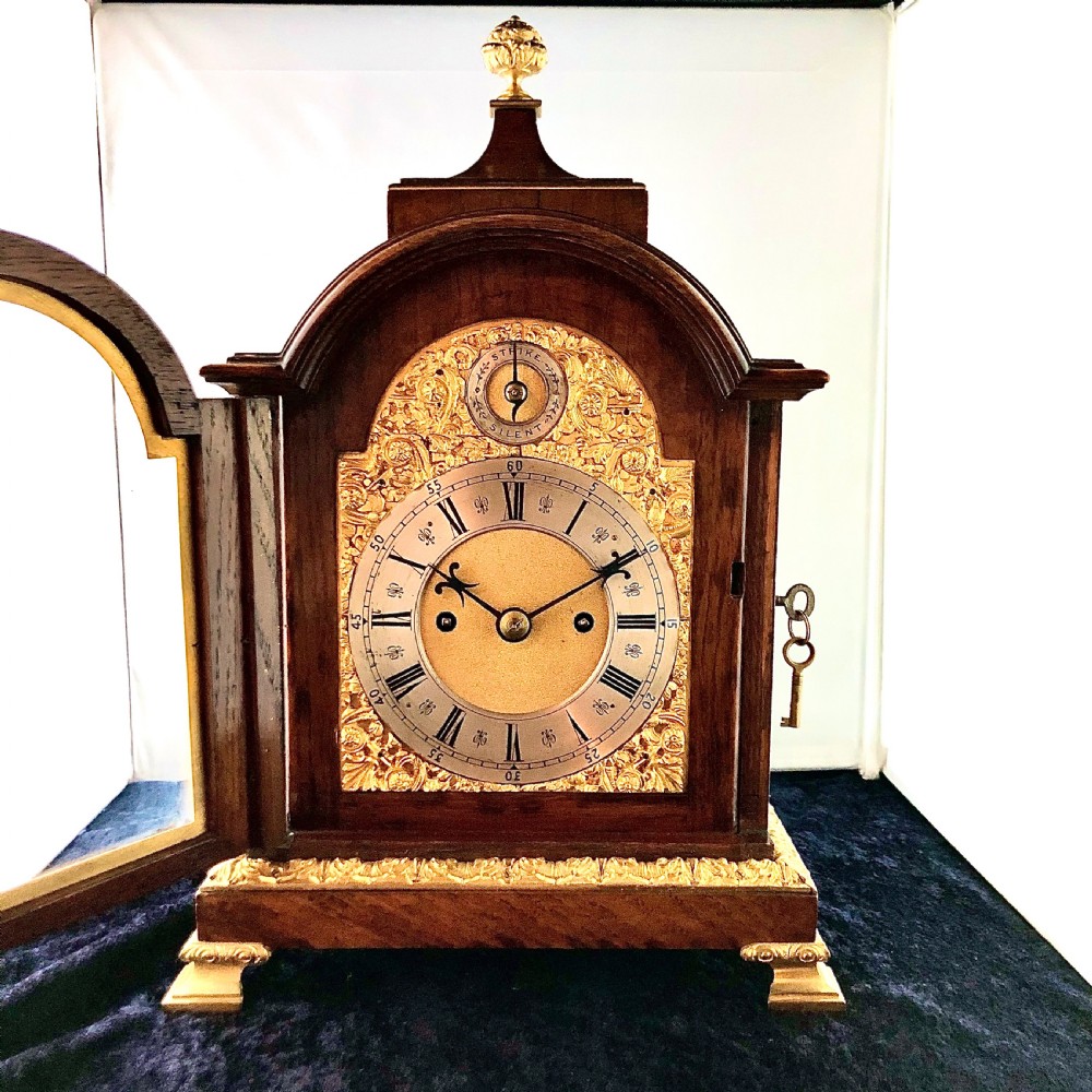 A late 19th-century mahogany bracket clock featuring an arched silvered dial, gilt-bronze caryatid mounts, and a brass finial top. View II