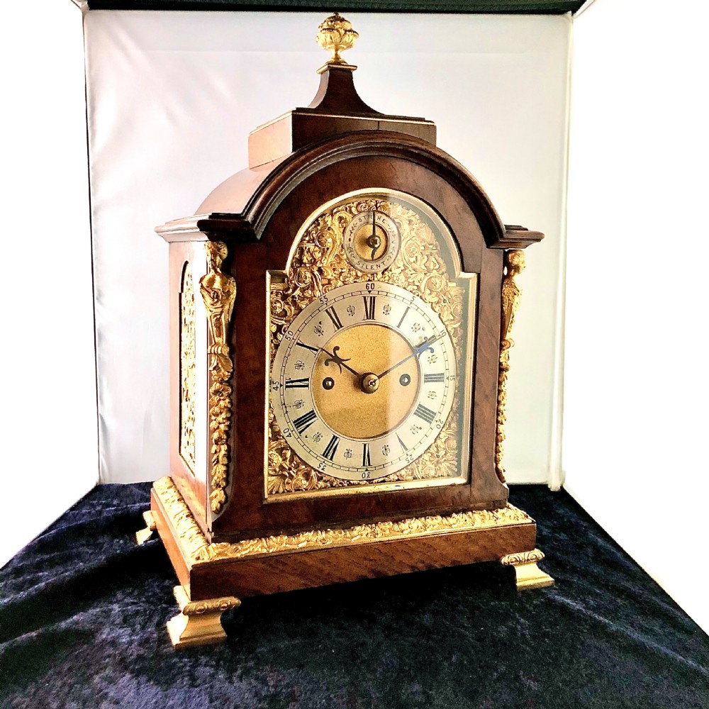 A late 19th-century mahogany bracket clock featuring an arched silvered dial, gilt-bronze caryatid mounts, and a brass finial top. View IV