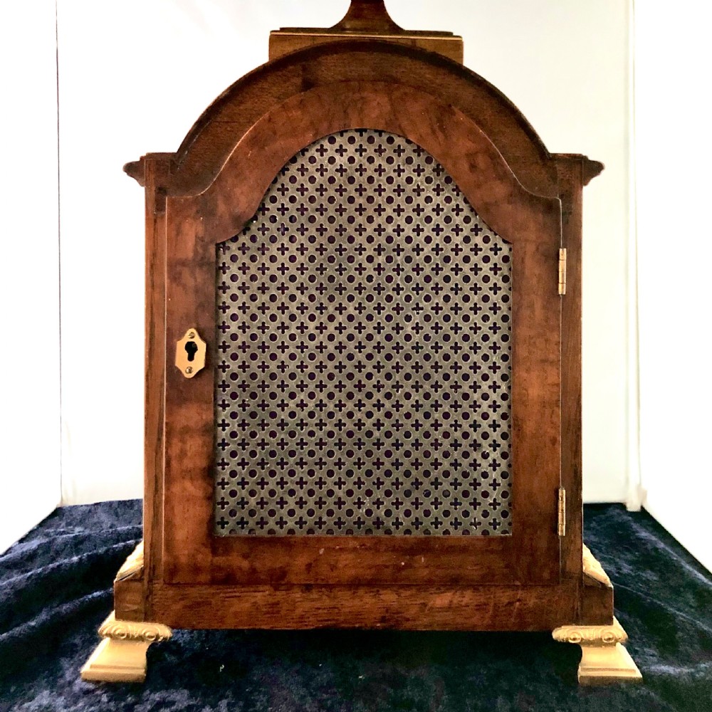 A late 19th-century mahogany bracket clock featuring an arched silvered dial, gilt-bronze caryatid mounts, and a brass finial top. View VII
