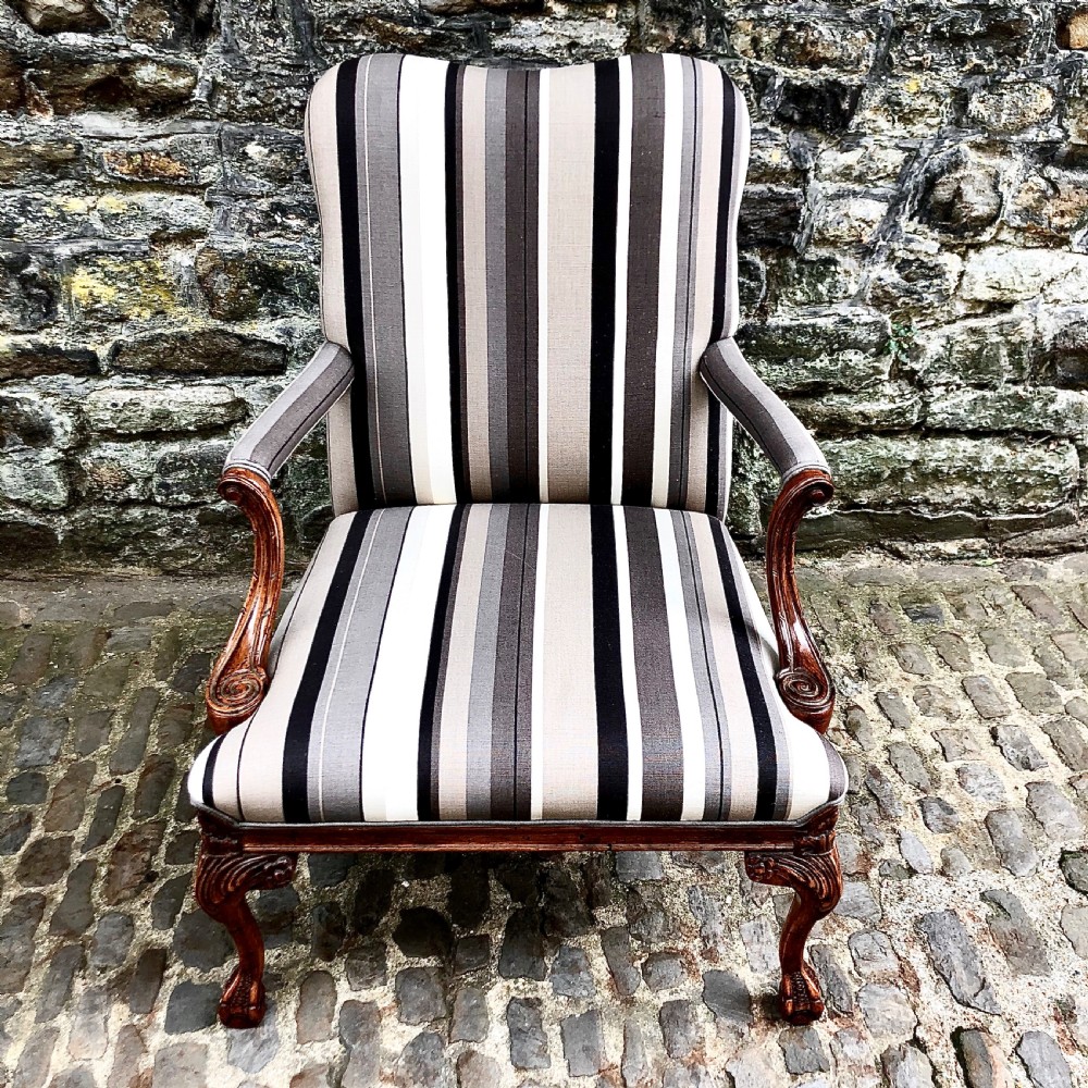 A pair of carved walnut Gainsborough armchairs upholstered in vertical striped neutral fabric featuring cabriole legs with claw and ball feet. View V