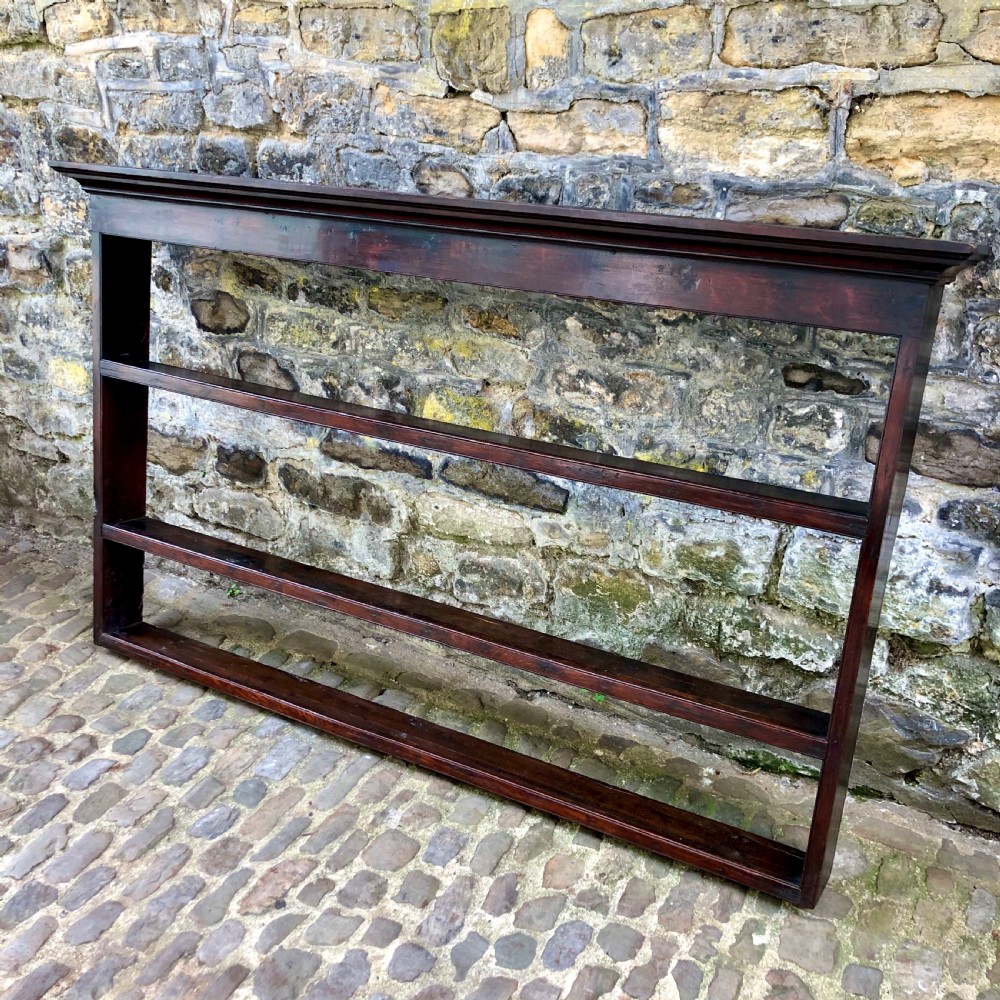 A dark oak 18th-century plate rack featuring three wide horizontal display shelves topped with a moulded cornice. View II