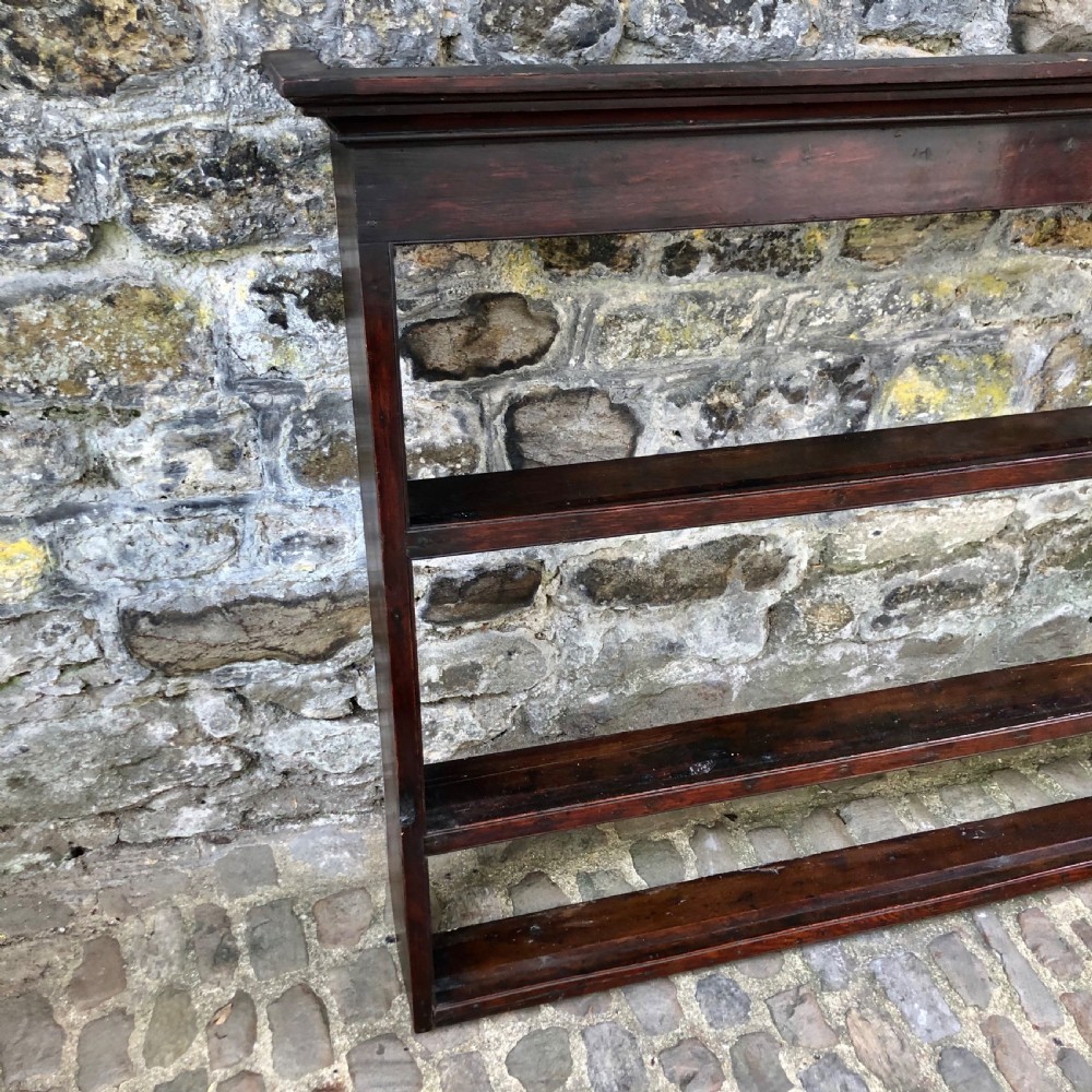 A dark oak 18th-century plate rack featuring three wide horizontal display shelves topped with a moulded cornice. View V