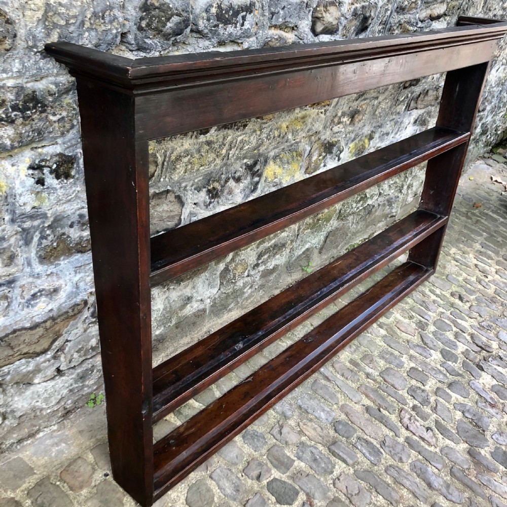 A dark oak 18th-century plate rack featuring three wide horizontal display shelves topped with a moulded cornice. View VI
