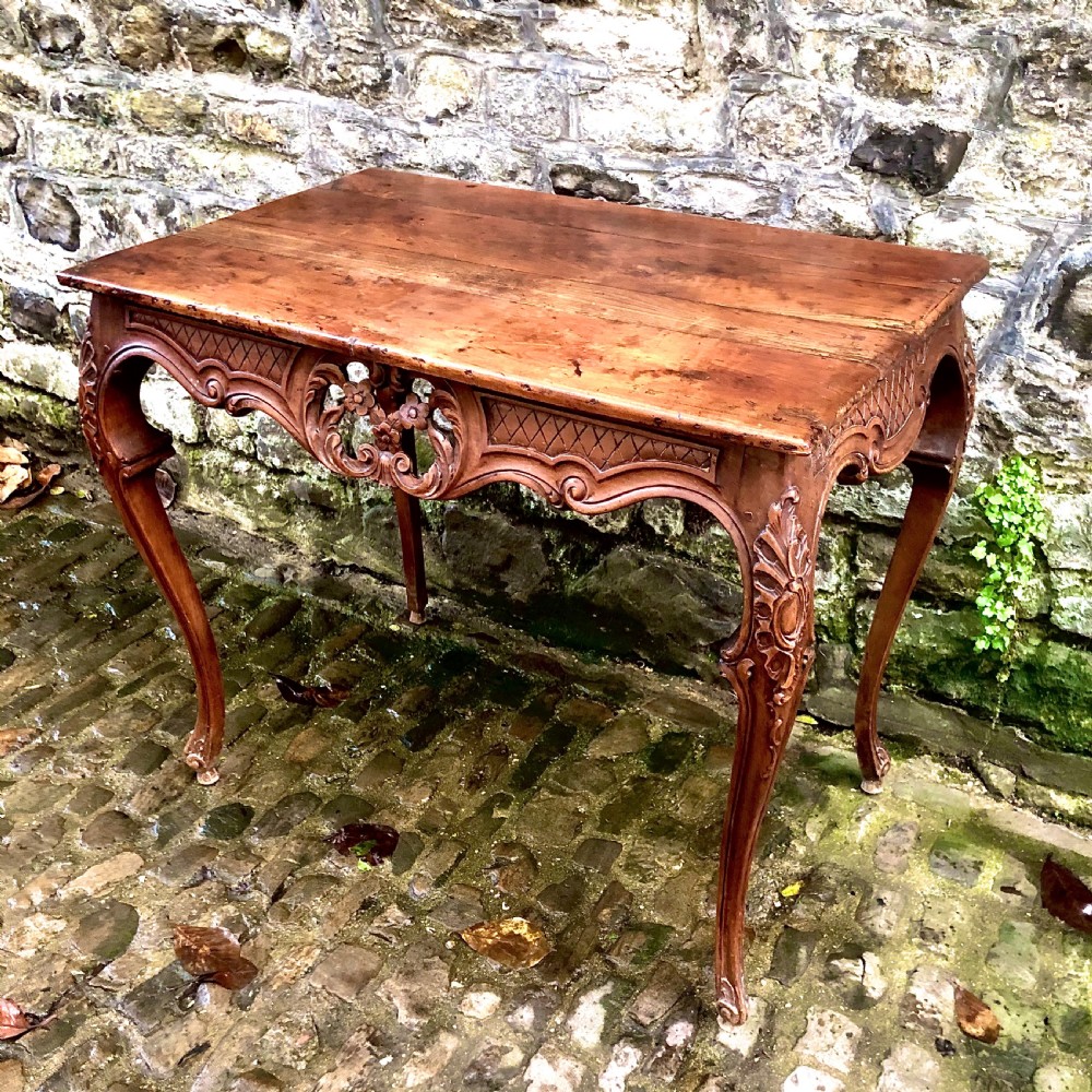 A French Louis XV style carved walnut centre table featuring cabriole legs and a decorative floral apron. View II