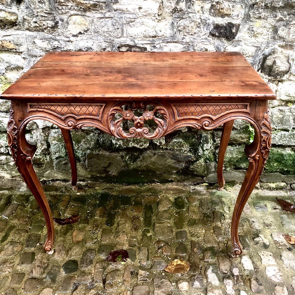 A French Louis XV style carved walnut centre table featuring cabriole legs and a decorative floral apron. View VI