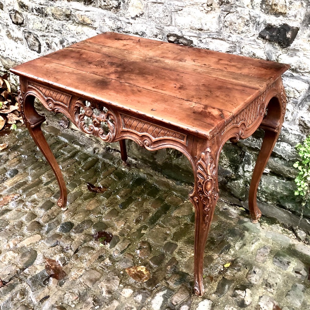 A French Louis XV style carved walnut centre table featuring cabriole legs and a decorative floral apron. View VII