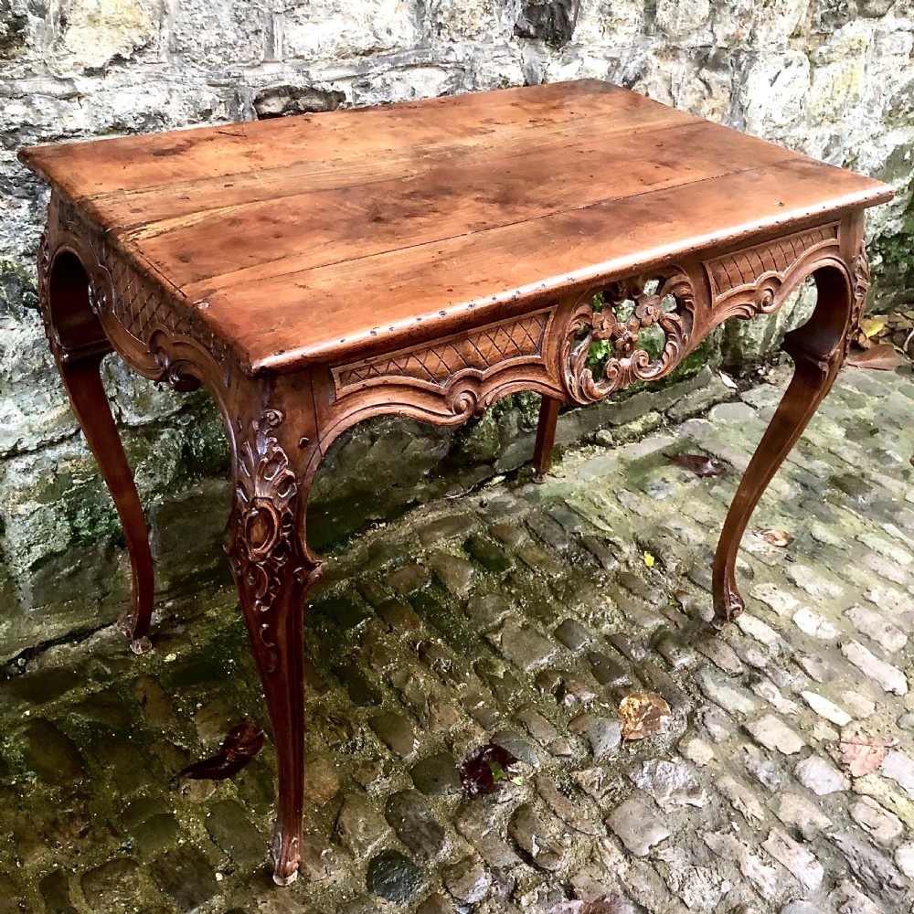 A French Louis XV style carved walnut centre table featuring cabriole legs and a decorative floral apron. View VIII