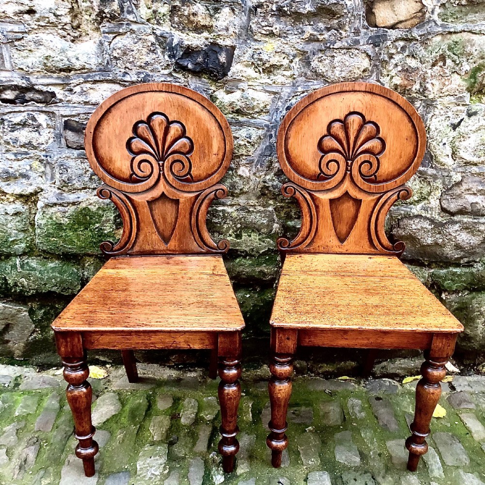 A pair of early Victorian oak hall chairs 