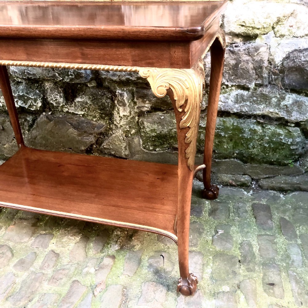 A late nineteenth-century two-tier walnut coffee table featuring carved gilded cabriole legs and a polished lower shelf. View V