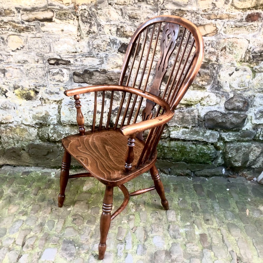 A mid-Victorian yew wood Windsor armchair featuring a hoop back, pierced central splat, turned legs, and a shaped wooden seat. View III