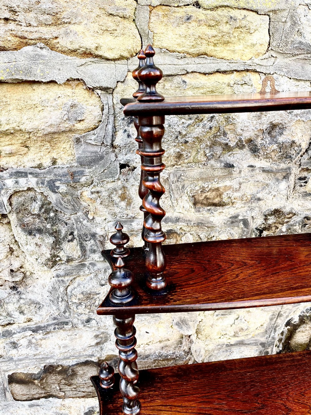 An early Victorian rosewood tiered shelf unit featuring five graduated tiers supported by turned barley twist columns and topped with finials. View VI