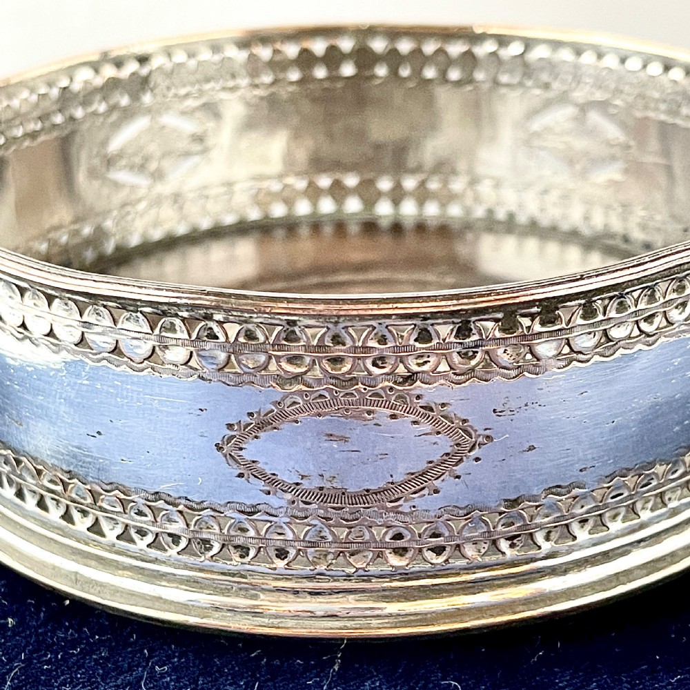 A circular Georgian Old Sheffield Plate silver wine coaster featuring hand-pierced reticulated patterns and engraved oval motif detailing. View III