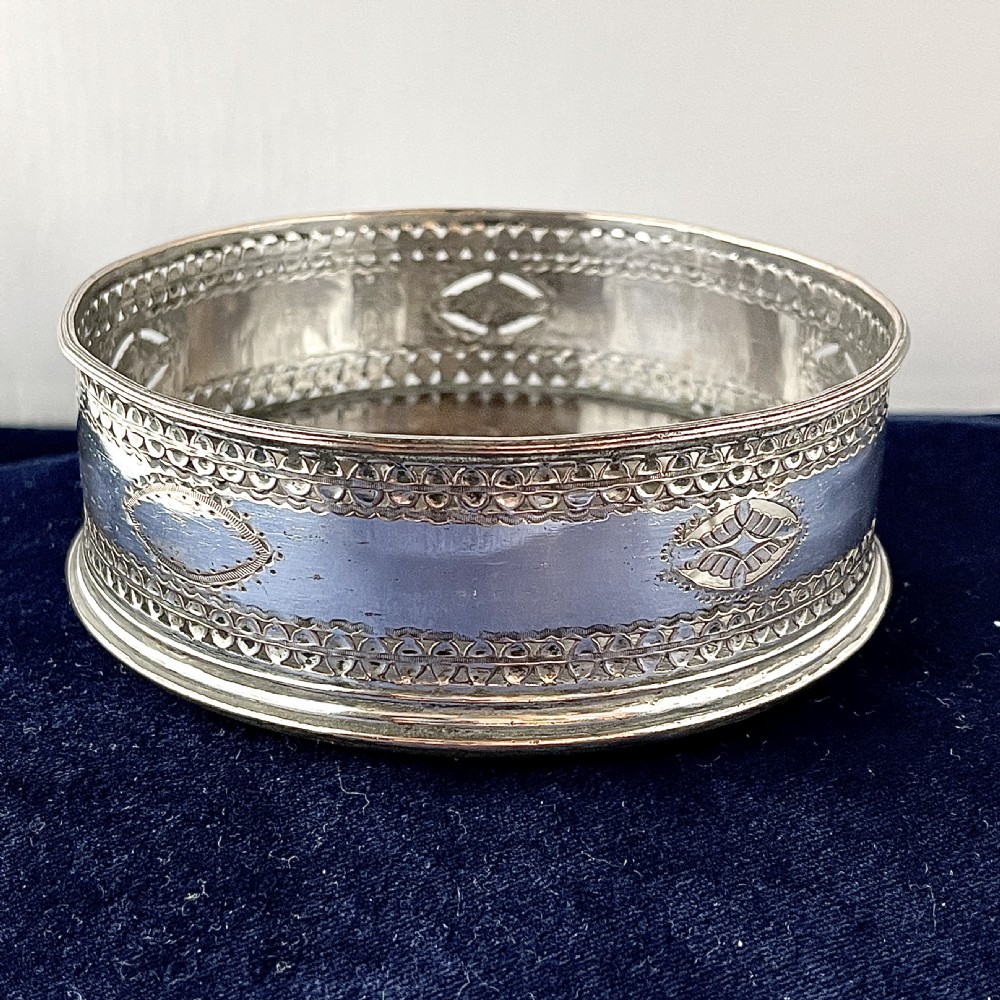 A circular Georgian Old Sheffield Plate silver wine coaster featuring hand-pierced reticulated patterns and engraved oval motif detailing. View IV