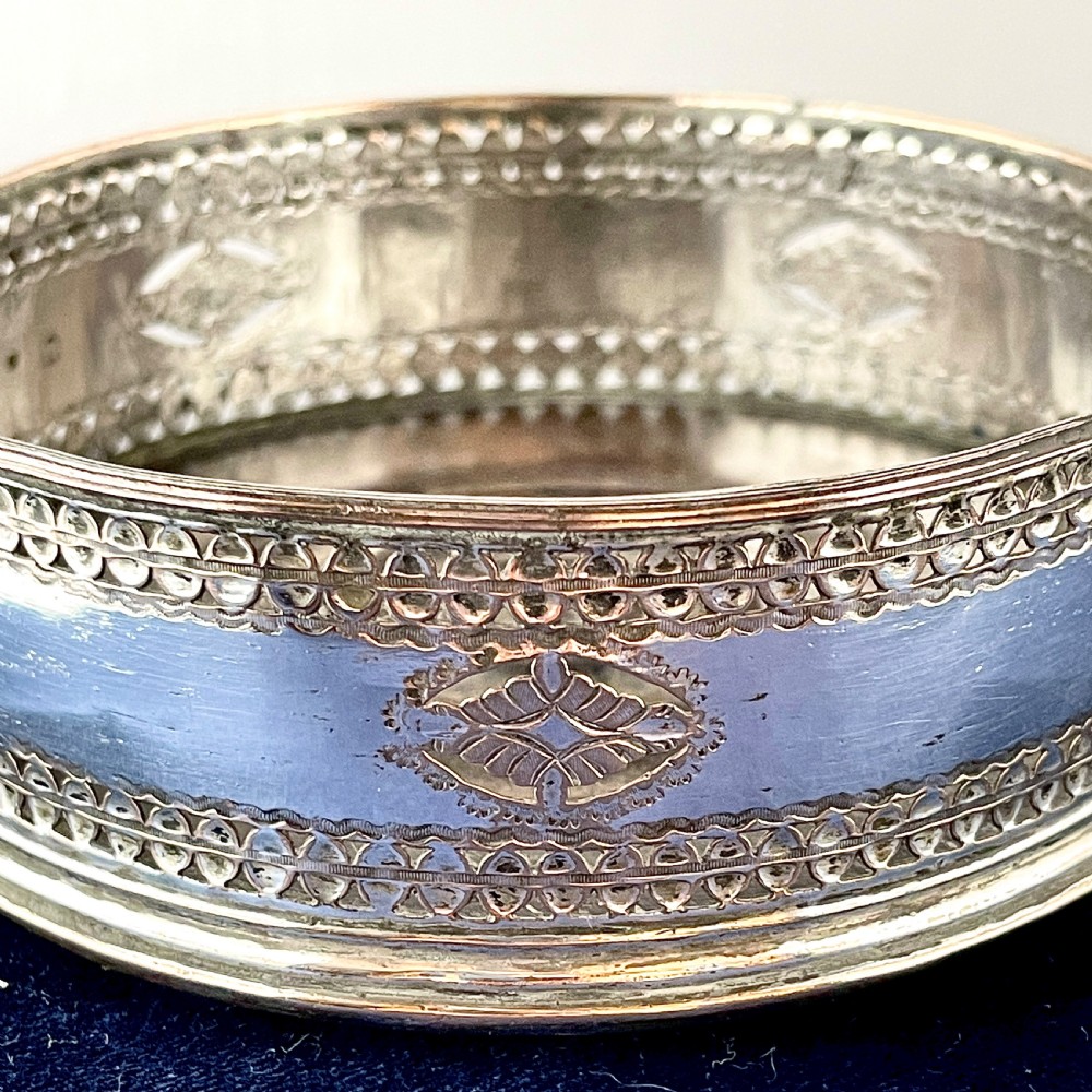 A circular Georgian Old Sheffield Plate silver wine coaster featuring hand-pierced reticulated patterns and engraved oval motif detailing. View V