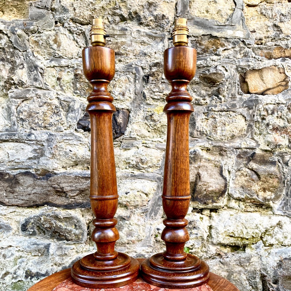 A pair of turned oak table lamps
