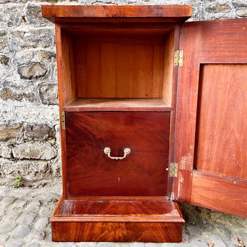 A pair of George IV flame mahogany pedestal cupboards featuring carved mouldings and plinth bases. View VII