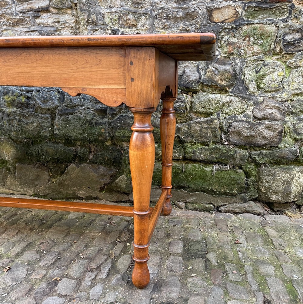 A long mid-Victorian walnut farmhouse dining table with turned legs connected by a low stretcher base. View IV
