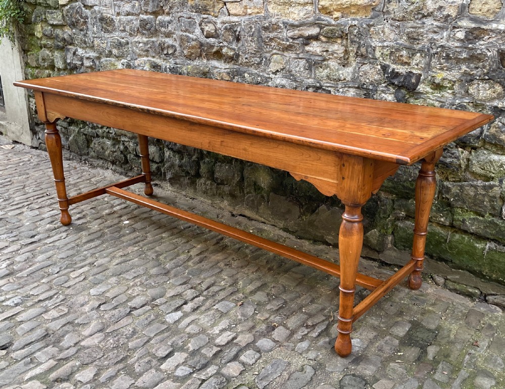 A long mid-Victorian walnut farmhouse dining table with turned legs connected by a low stretcher base. View V