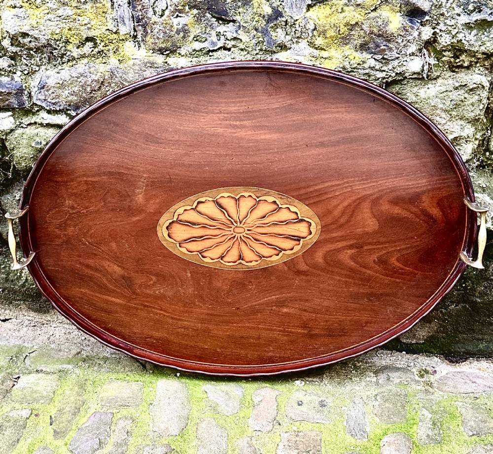 An oval George III mahogany serving tray featuring a central fan shell patera inlay and two brass carrying handles. View II