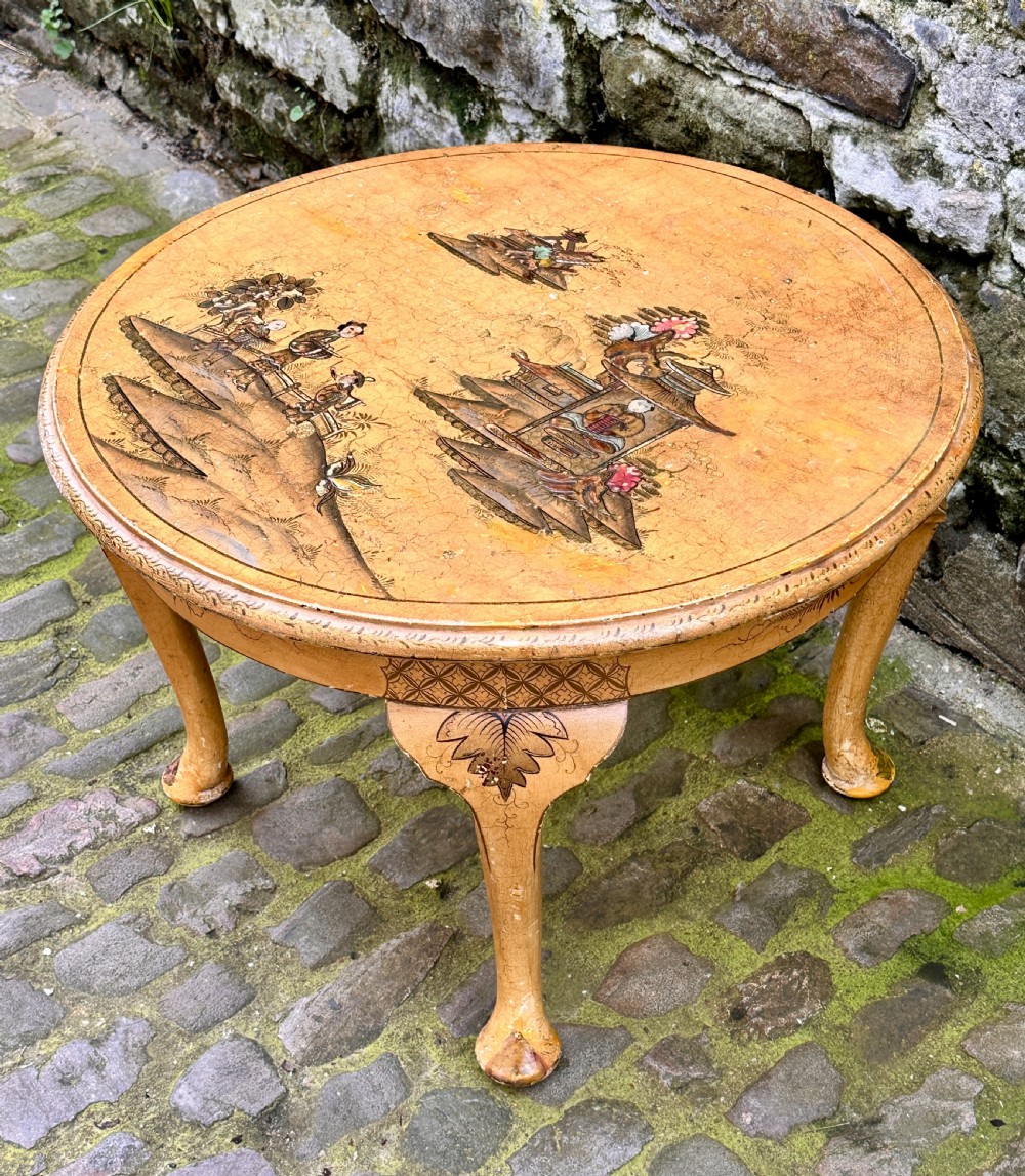 A low oval Chinoiserie coffee table featuring hand-painted East Asian landscape scenes on a cream lacquered top with cabriole legs. View VII