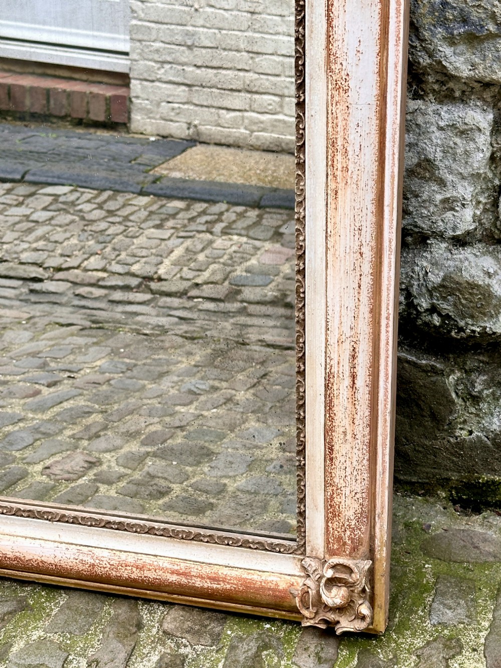 Mid 19th century arched French overmantel mirror with carved cartouche scroll cresting and a distressed cream and gold finish. View IV