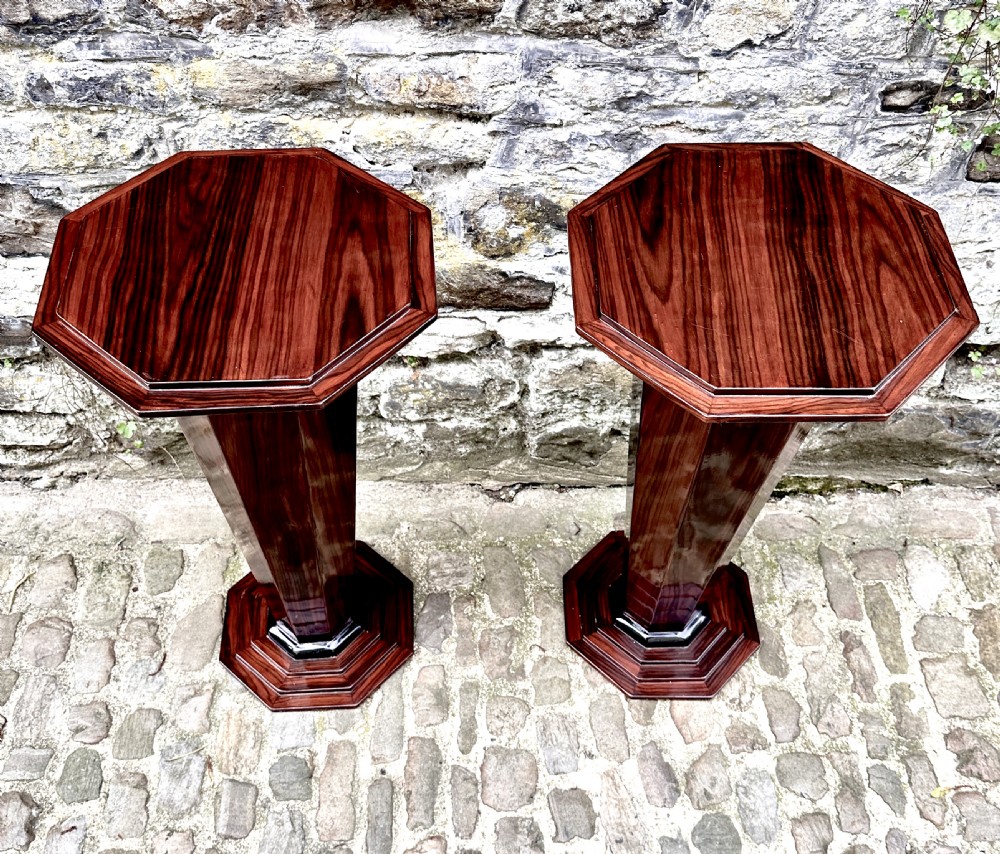 A pair of polished Art Deco wooden pedestal lamp tables with octagonal tops, faceted tapering columns, and stepped bases. View III