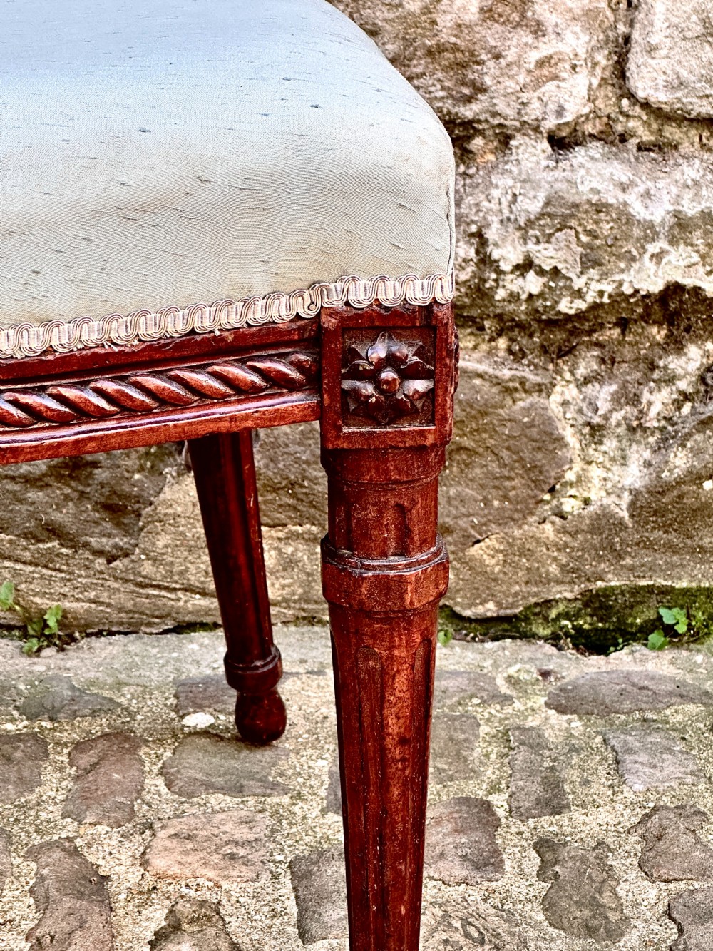 A set of four George III mahogany side chairs with oval upholstered backs, rope-twist carved borders, and fluted turned legs. View IV