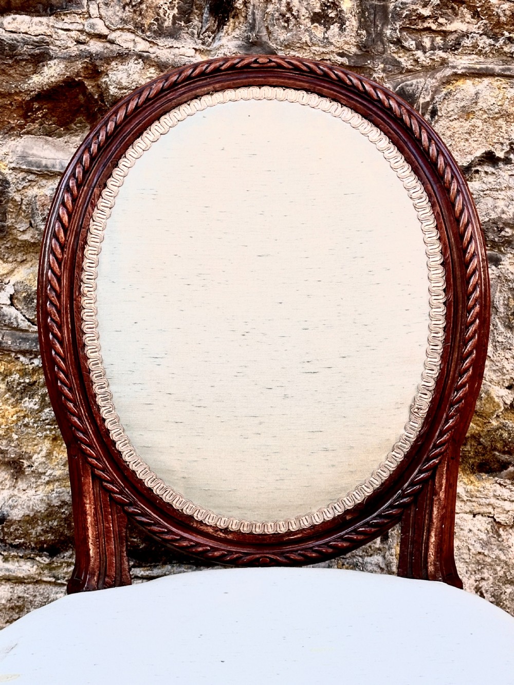 A set of four George III mahogany side chairs with oval upholstered backs, rope-twist carved borders, and fluted turned legs. View V