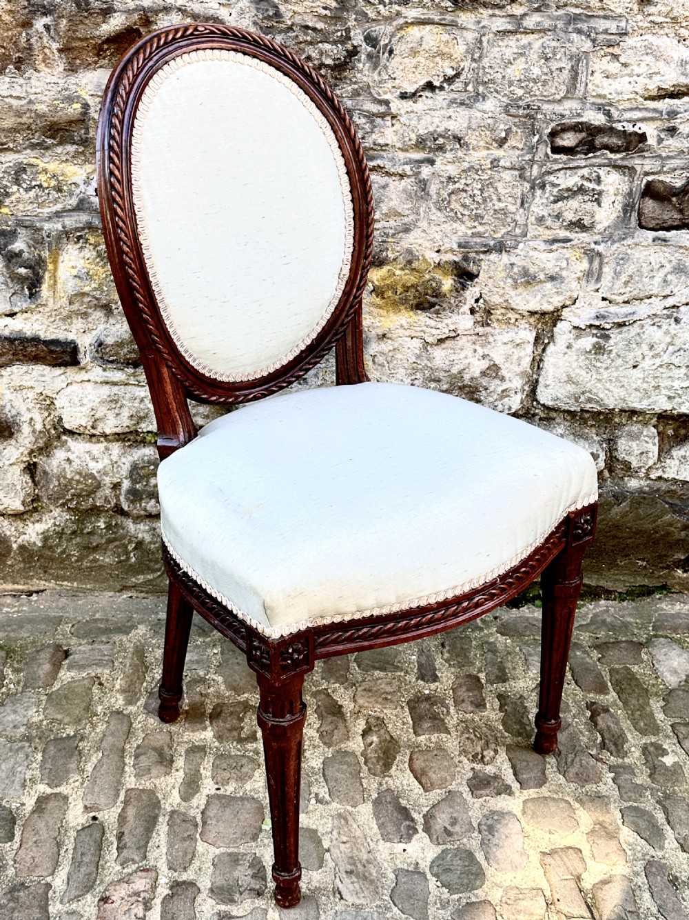 A set of four George III mahogany side chairs with oval upholstered backs, rope-twist carved borders, and fluted turned legs. View VIII