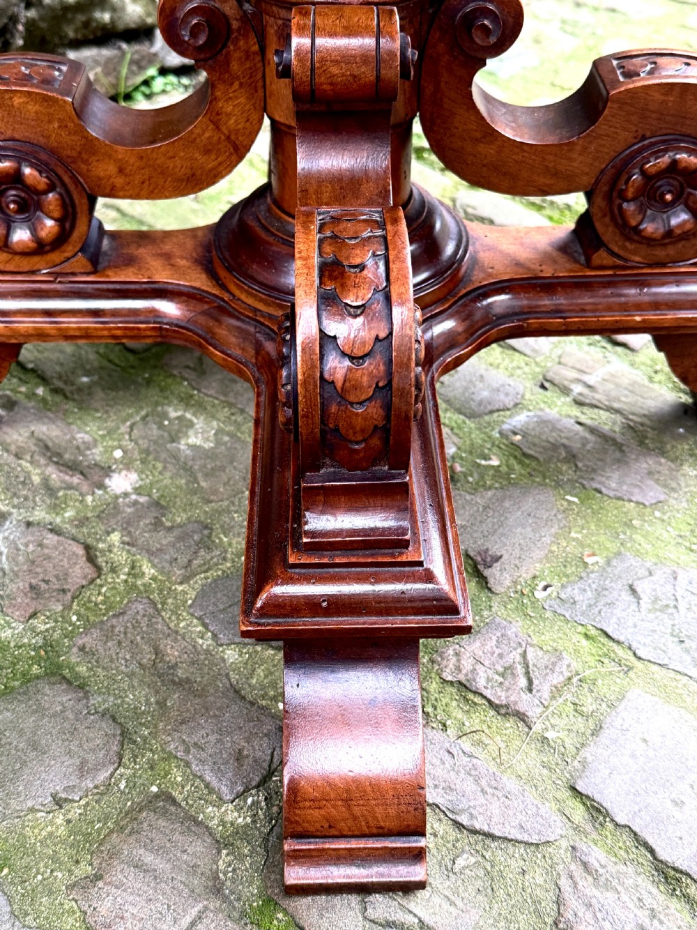 An octagonal mid-Victorian centre table crafted from walnut with a veneered top, turned pedestal stem, and carved four-legged scroll base. View IX