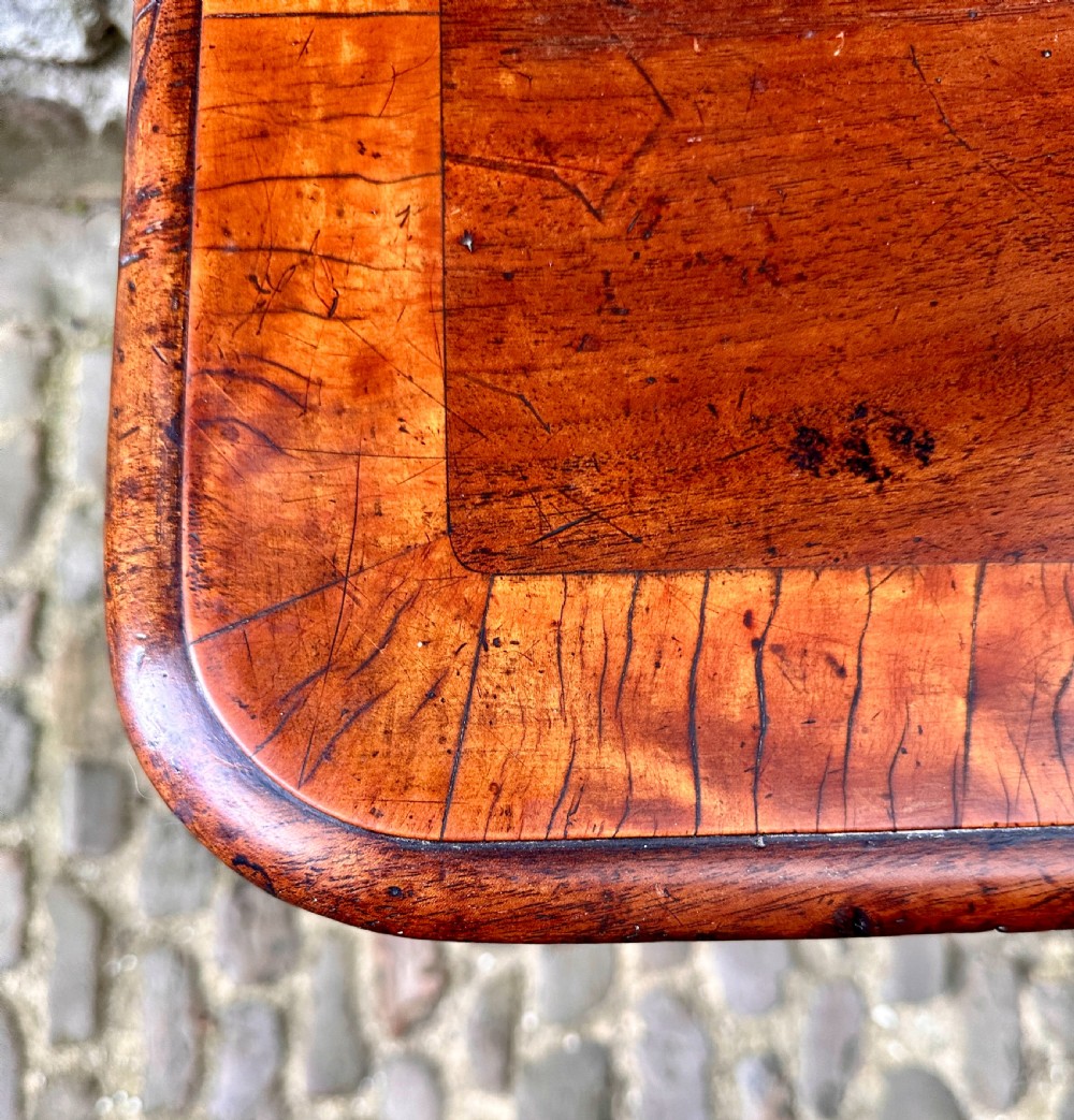 A Regency birchwood lamp table featuring a crossbanded top with rounded corners, a central turned column, and four splayed legs. View II