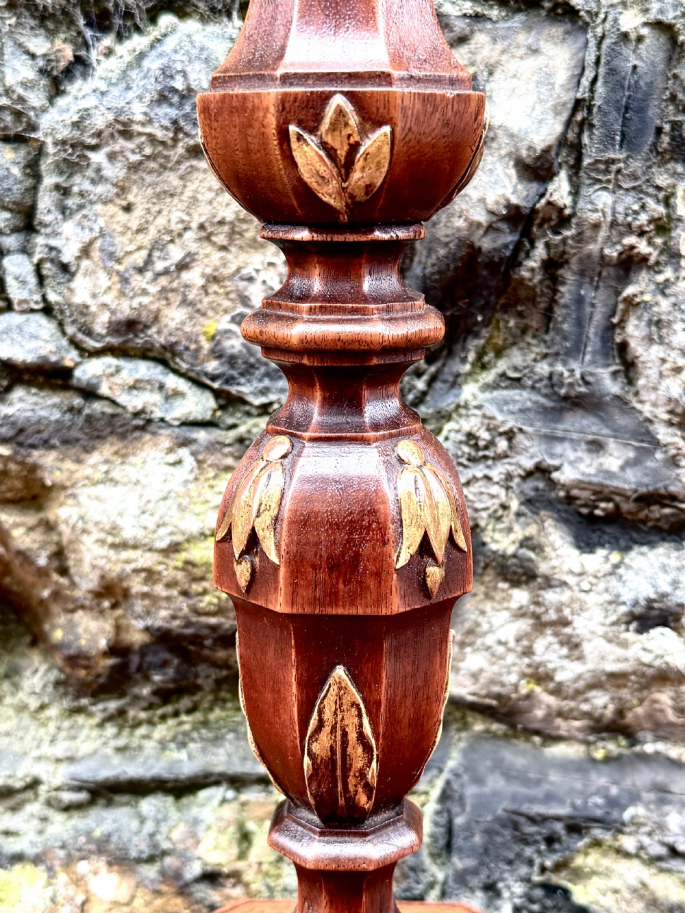 A pair of turned Adam style mahogany candlesticks featuring carved leaf detailing and octagonal bases. View V