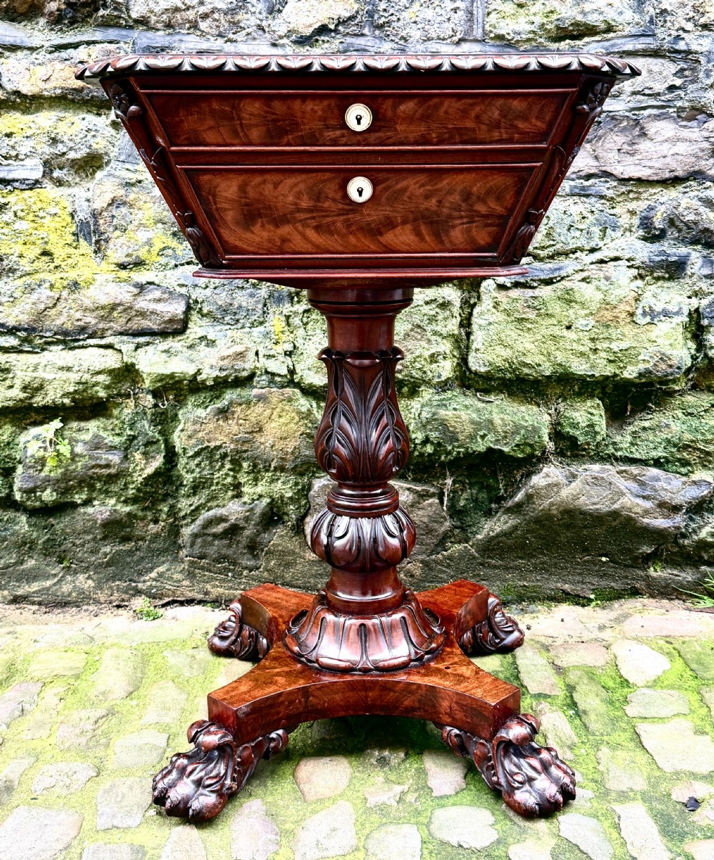A William IV flame mahogany work table featuring a gadrooned top edge, two drawers with bone escutcheons, a carved pedestal stem, and a quadform base with claw feet. View II