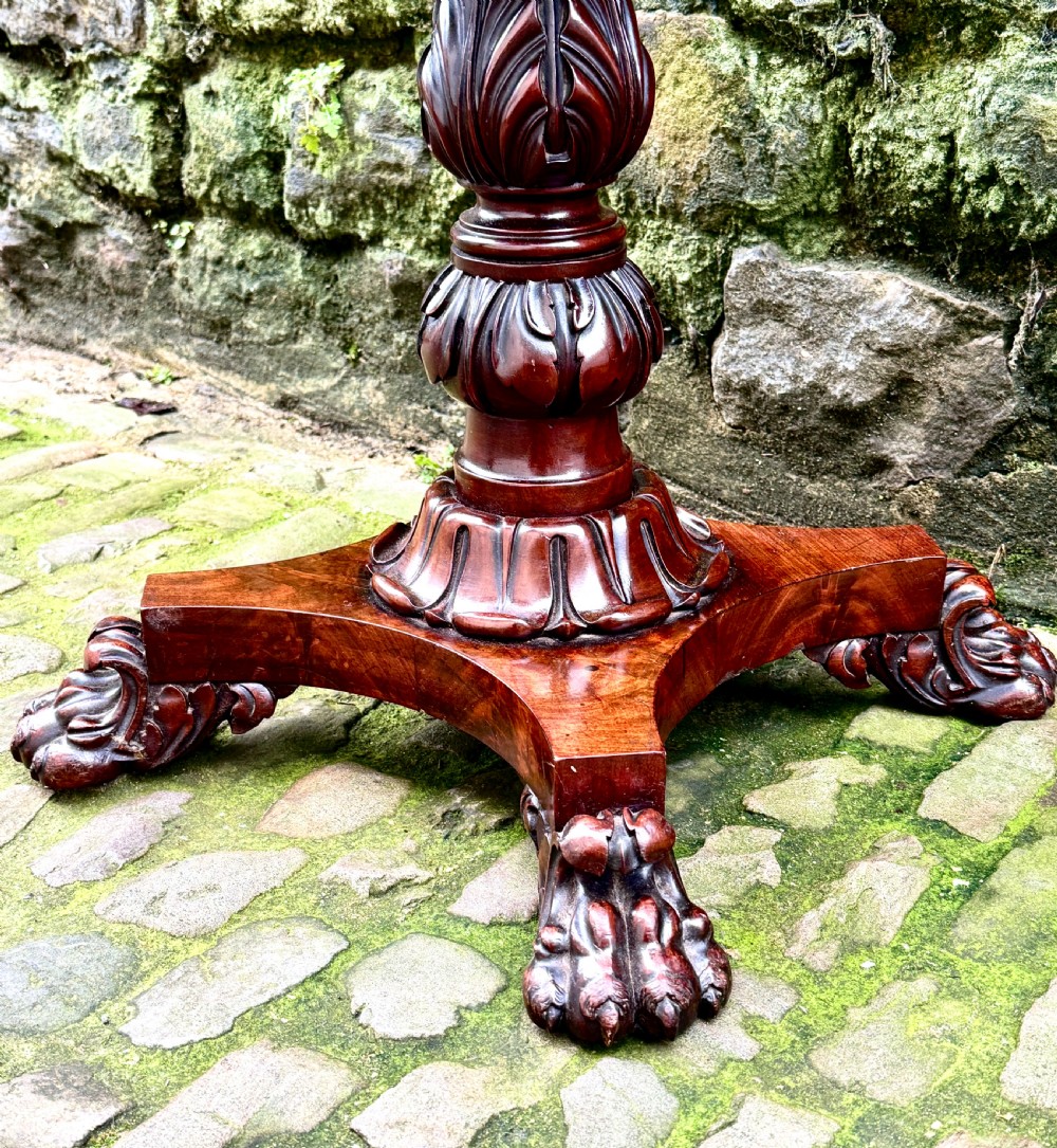 A William IV flame mahogany work table featuring a gadrooned top edge, two drawers with bone escutcheons, a carved pedestal stem, and a quadform base with claw feet. View VI