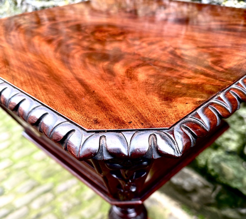 A William IV flame mahogany work table featuring a gadrooned top edge, two drawers with bone escutcheons, a carved pedestal stem, and a quadform base with claw feet. View XIII